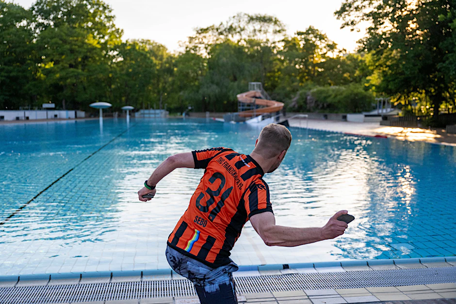 Sebastian Naumann, Abteilungsleiter Titschern beim THC Franziskaner FC, wirft an einem Trainingstag einen Stein in das 75 Meter lange Nichtschwimmerbecken im Sommerbad Kreuzberg.