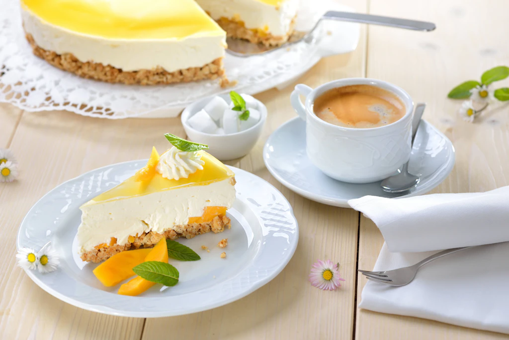 Dieser Mango-Frischkäsekuchen mit einem Boden aus Kekskrümeln hat nie einen Backofen gesehen. Dazu passt perfekt eine Tasse Caffè Crema.