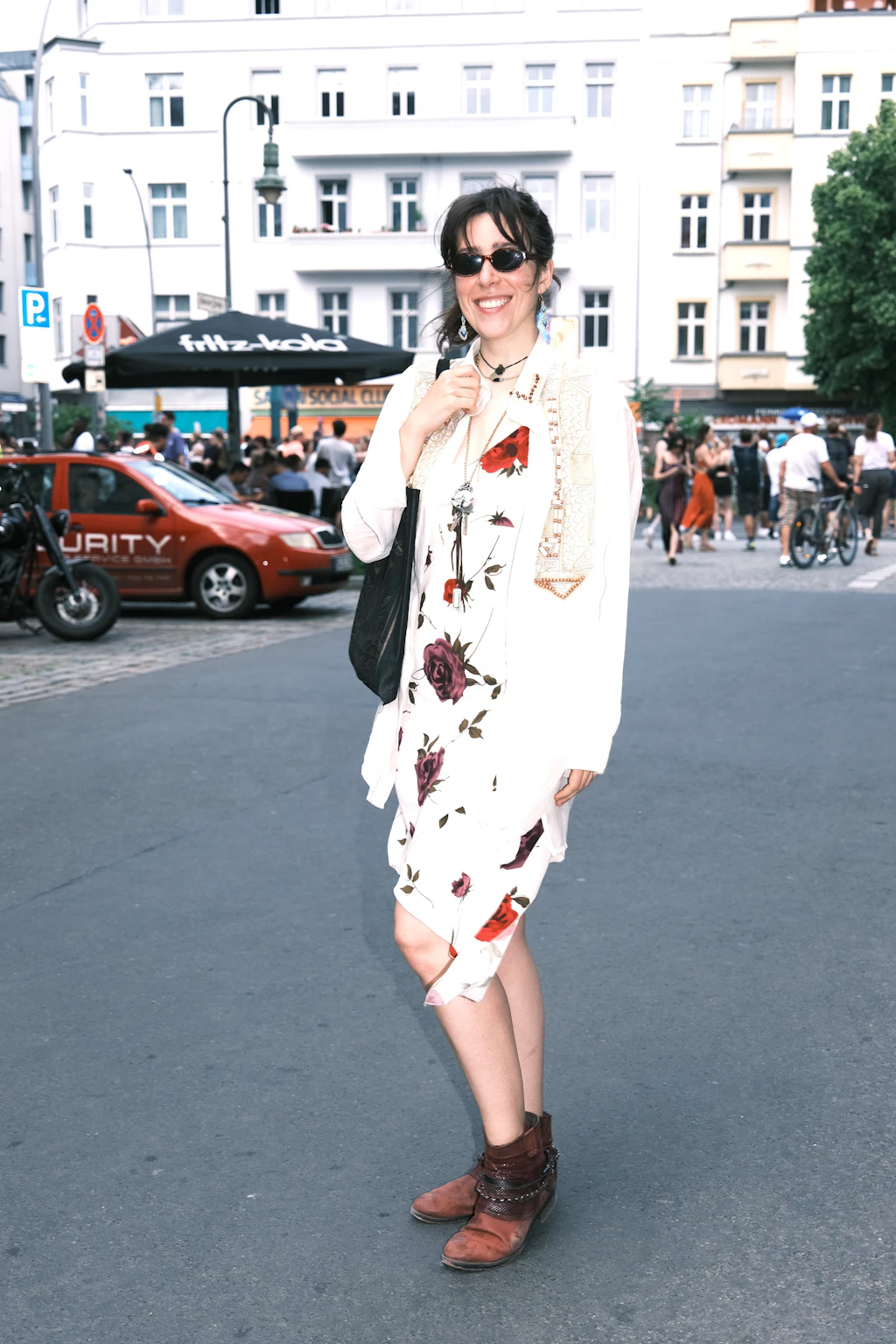 Obwohl sie aus Kreuzberg kommt, ist es für Marie-Claire erst der zweite Karneval der Kulturen. Passend zu ihrem Künstlernamen „Hidden Rose“, unter dem sie malt und Musik macht, trägt sie ein Kleid mit Rosen-Print. Darüber kombiniert sie ein luftiges, aufwendig besticktes Hemd von ihrer Oma. Komplettiert wird das Outfit durch Schmuck mit türkisfarbenen Perlen. Die Ohrringe sind ein Geschenk ihrer Schwester: Diese hatte sie von einer Kundin im Friseursalon bekommen und musste dabei direkt an Marie-Claire denken.