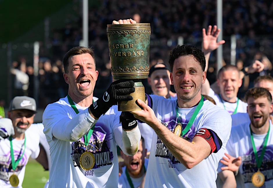 Aues Torhüter Martin Männel und Kapitän Marcel Bär (v.l.) stemmen nach dem Sieg gegen den FSV Zwickau den Landespokal empor.