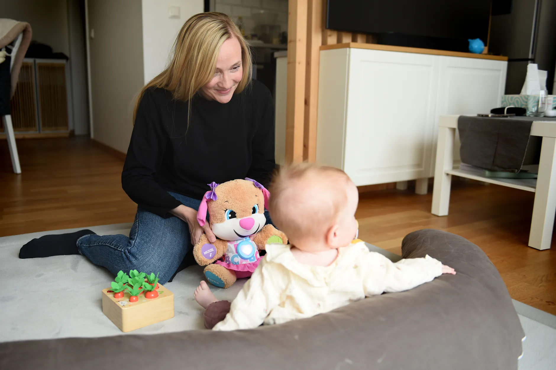 Jennifer S. und ihre Tochter spielen zusammen im Wohnzimmer. Sie ist ihr großes Glück.