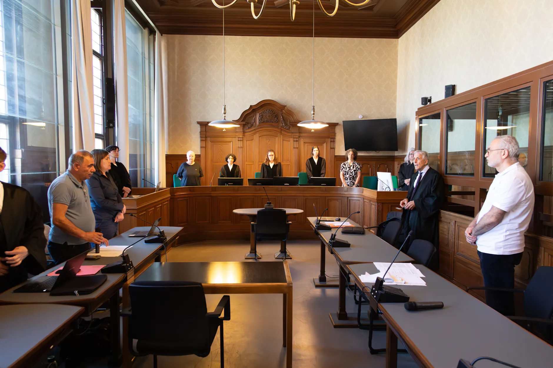 Der Verteidiger (2.v.r.) und der Dolmetscher (r.) vor Gericht. Der Angeklagte hat sich nicht vorführen lassen.