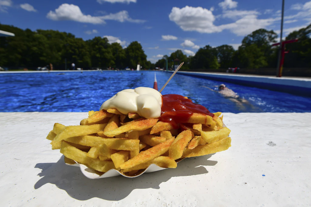 Pommes mit Ketchup und Mayo am Beckenrand: Nirgendwo schmecken schlechte Pommes besser als im Freibad!
