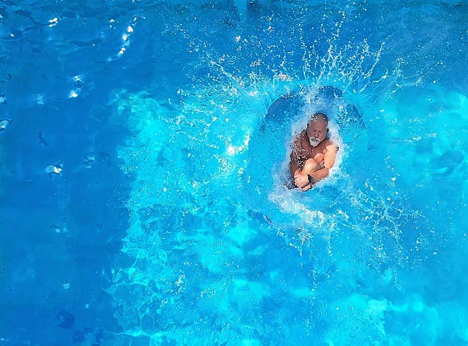 Ein älterer Mann macht eine Arschbombe ins strahlend blaue Freibadwasser. Erlaubter Spaß oder pure Rücksichtslosigkeit? Wir klären auf.