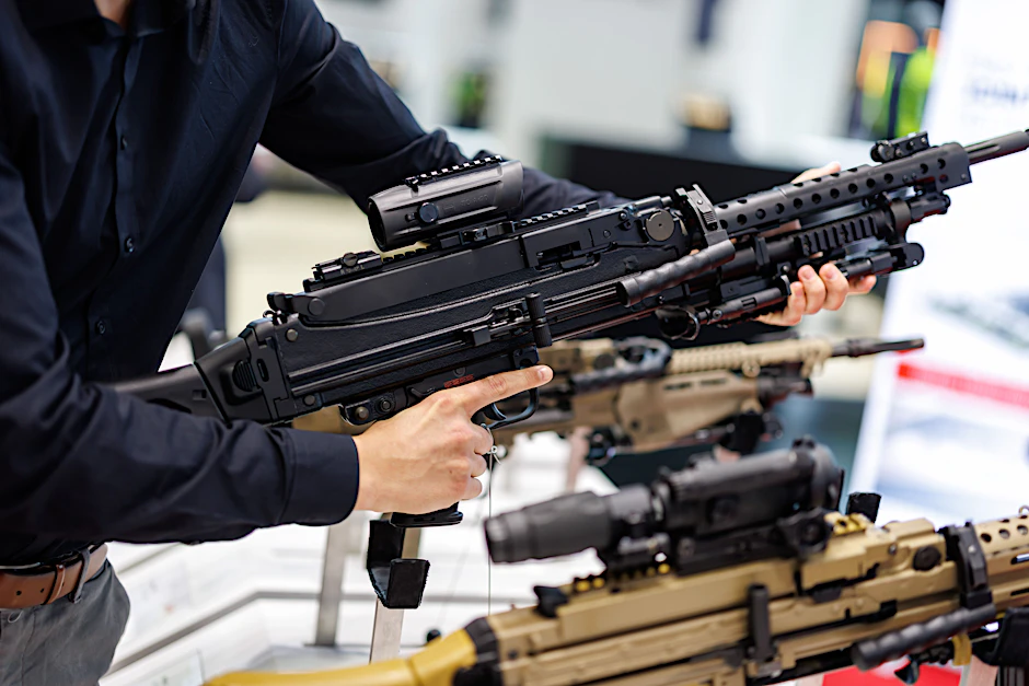 Eine Person hält ein Maschinengewehr von Heckler & Koch.