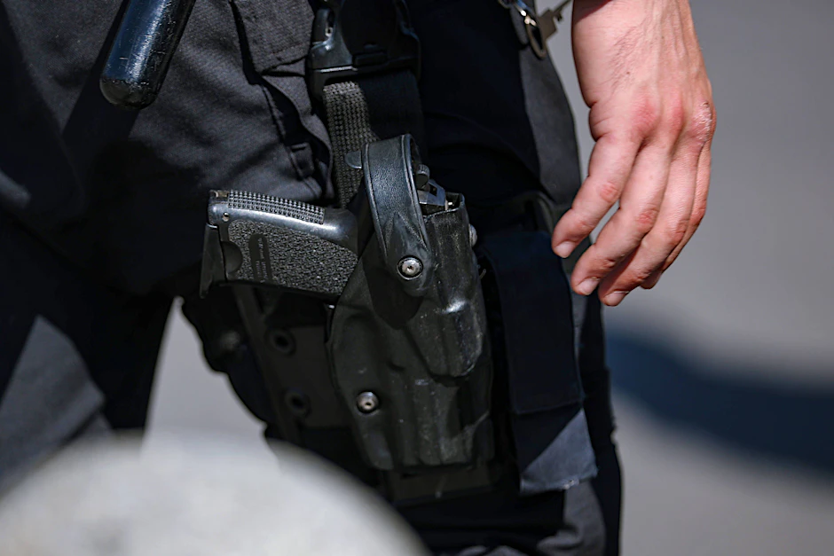 Nahaufnahme der Dienstwaffe eines Polizisten