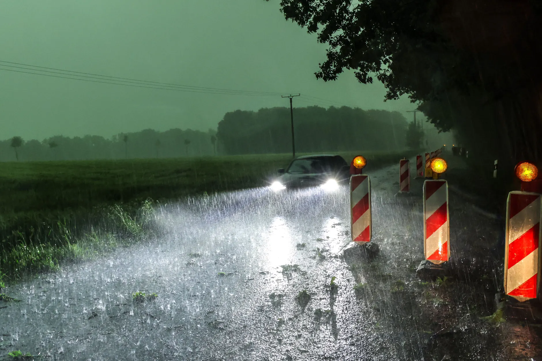 Ein Auto fährt über eine überflutete Straße: In NRW wüteten am Wochenende bereits heftige Unwetter. Es die Gewitter-Saison hat gerade erst angefangen.