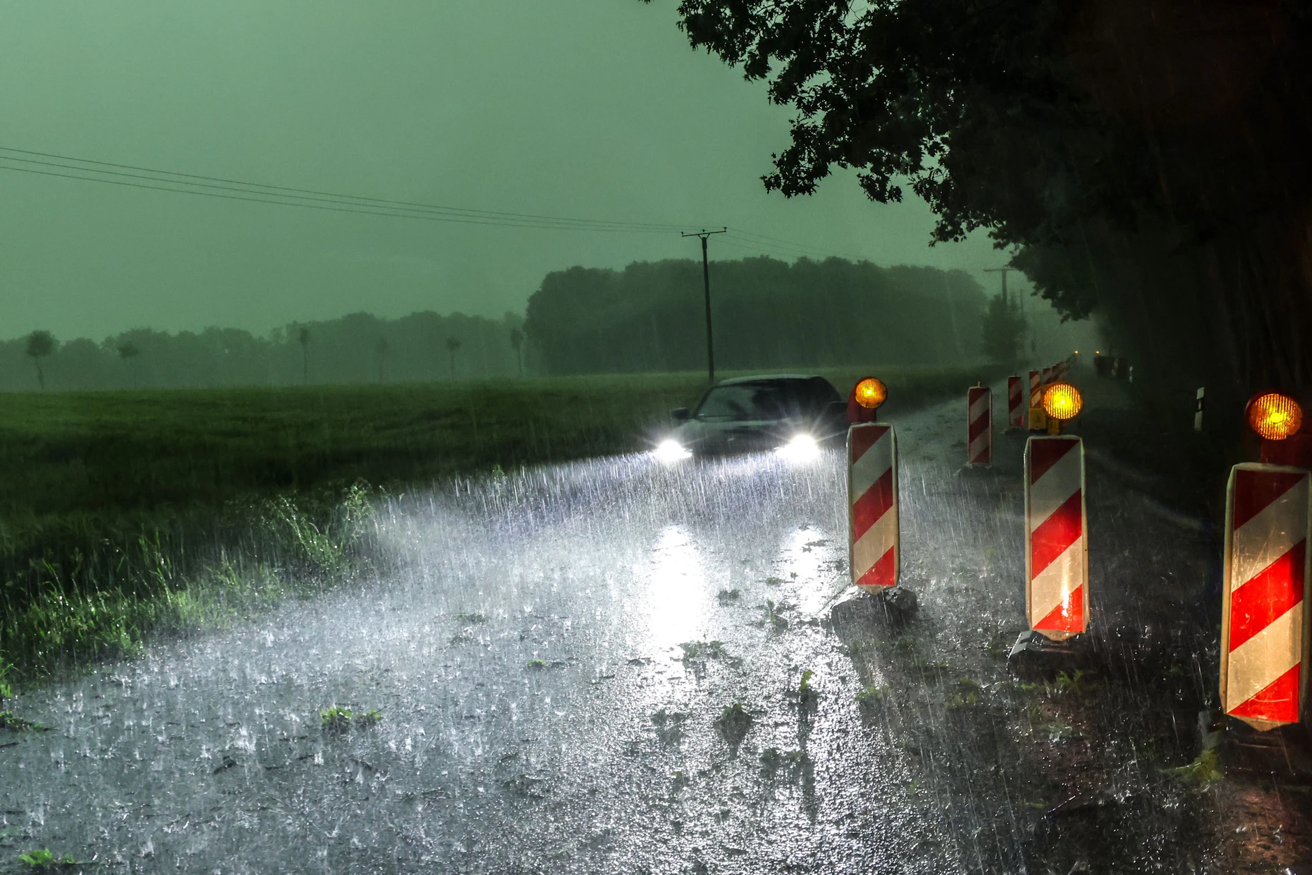 Ein Auto fährt über eine überflutete Straße: In NRW wüteten am Wochenende bereits heftige Unwetter. Es die Gewitter-Saison hat gerade erst angefangen.