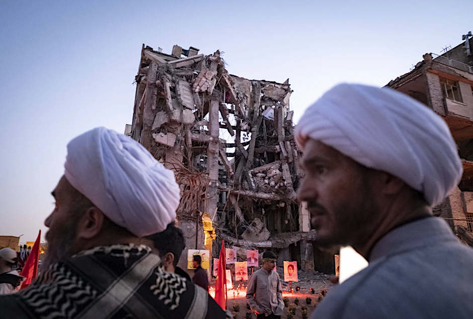 Geistliche vor einem zerstörten Wohnhaus in Teheran: Es geht um 300 Milliarden Dollar Wiederaufbauhilfe.