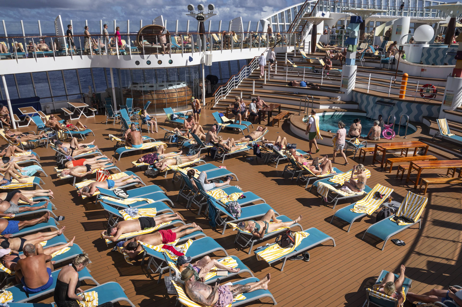 Passagiere des Kreuzfahrtschiffs AIDAblu genießen auf dem Sonnendeck die Reise durch die Karibik. Doch auch hier sind mehrere Liegen durch Handtücher blockiert.