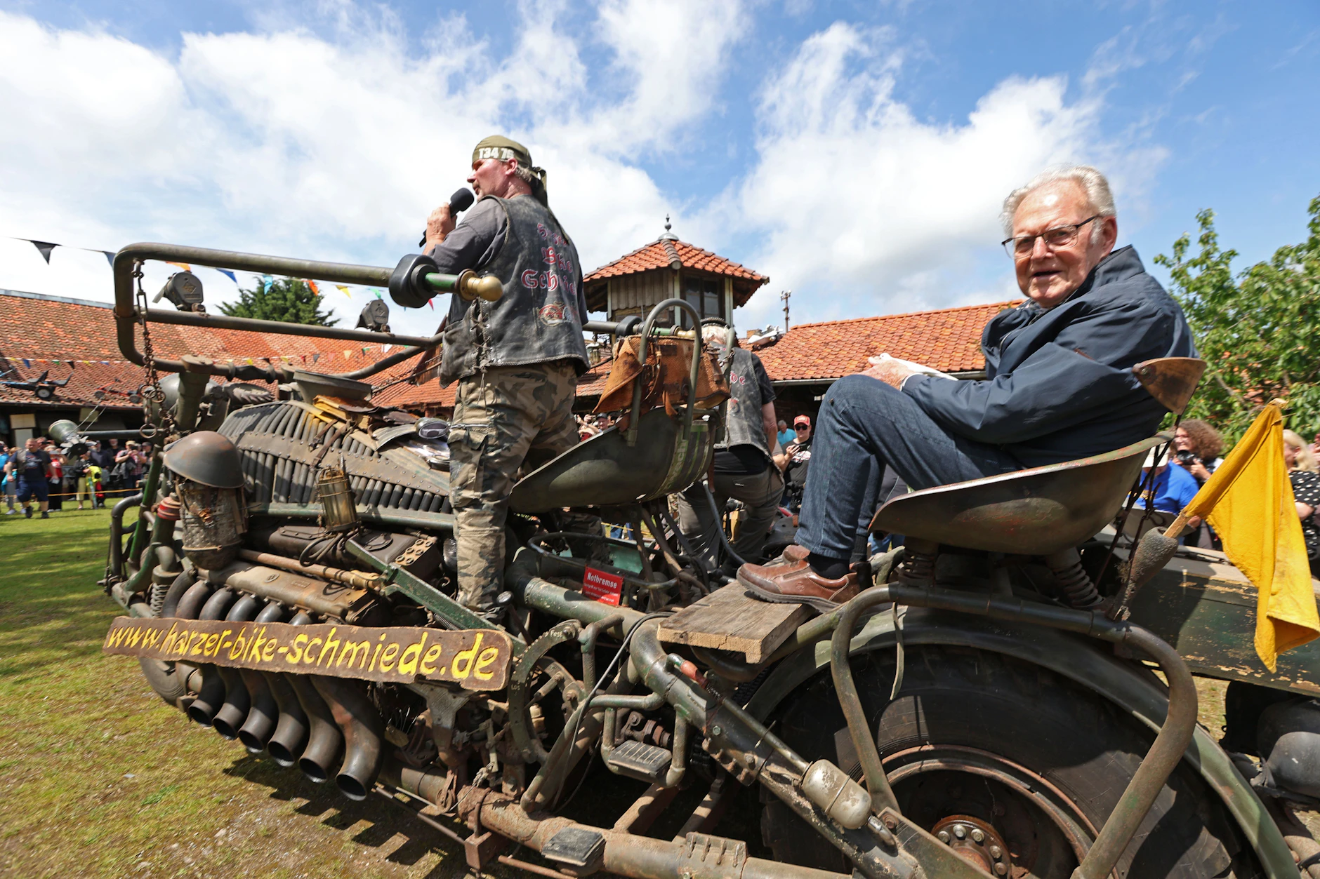 DDR-Radsportlegende „Täve“ Schur (r.) sitzt beim Harzer Bikeschmiede-Festival auf einem tonnenschweren Panzerbike, ausgestattet mit einem V12-Motor aus einem russischen T-55 Kampfpanzer.