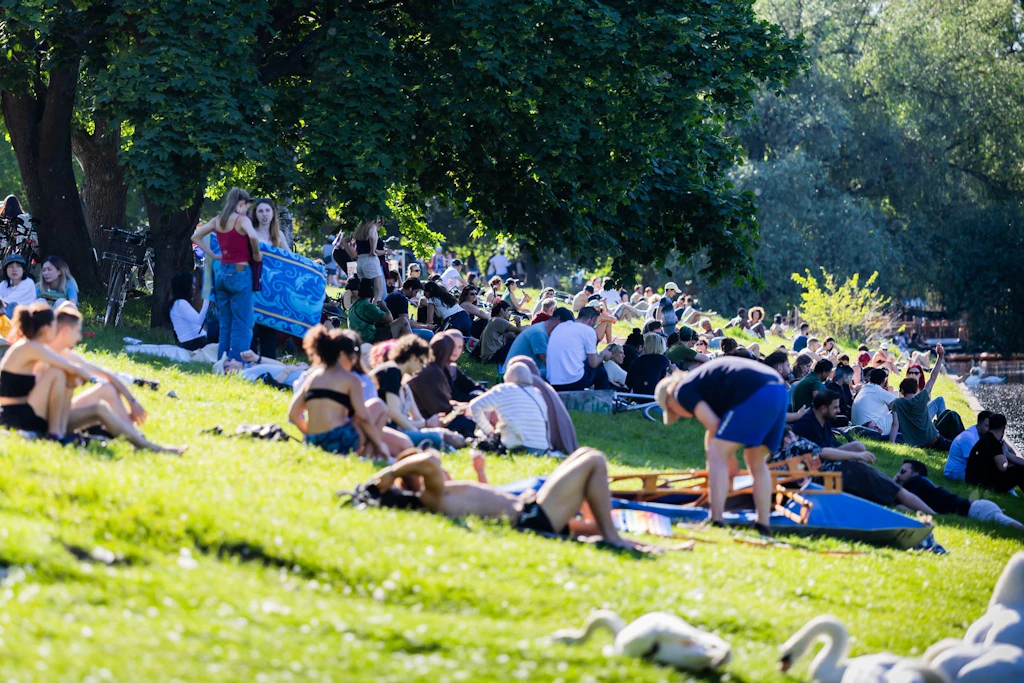 Menschen genießen das sommerliche Wetter in Kreuzberg am Landwehrkanal. Doch wann wird die Hitze zum Risiko?