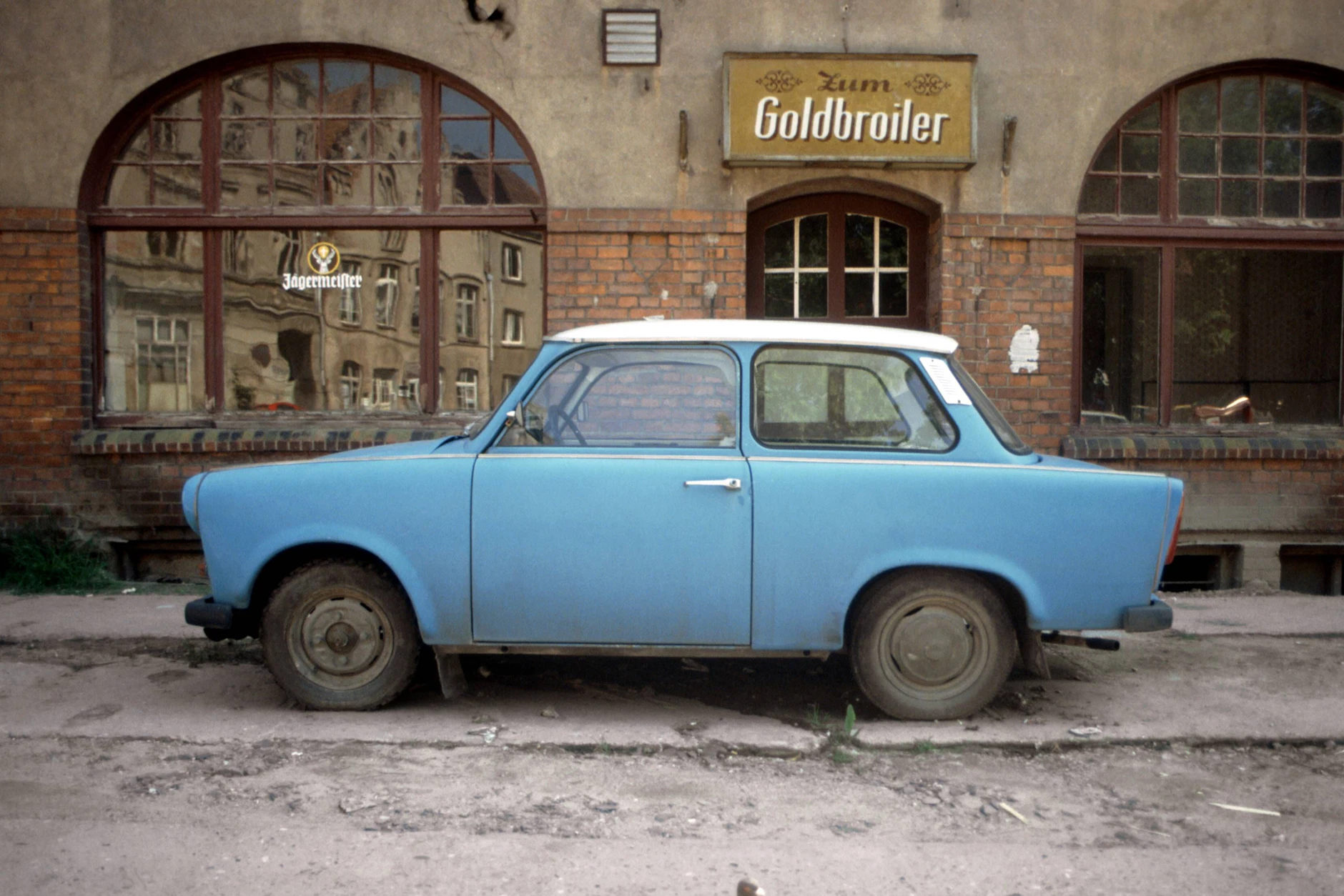 Ein himmelblauer Trabant parkt kurz nach der Wende vor der Gaststätte Zum Goldbroiler in Wismar.