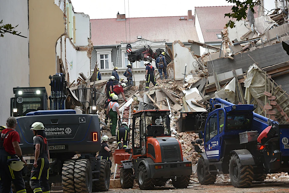 Einsatzkräfte von Feuerwehr und Technischem Hilfswerk arbeiten in den Trümmern eines eingestürzten Gebäudes. Das Haus ist am 18.05.2026 eingestürzt, Retter suchen noch nach Vermissten.