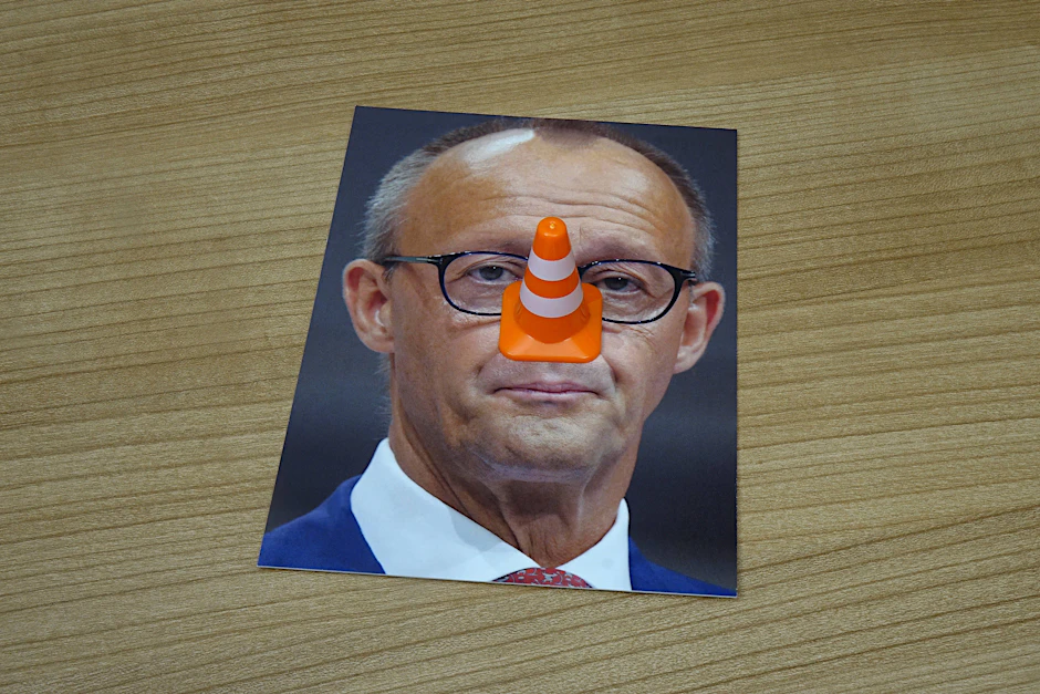 Porträt von Friedrich Merz mit Verkehrskegel als Pinocchio-Porträt: Ausgesprochen kann dies einen Strafbefehl in vierstelliger Höhe zur Folge haben.