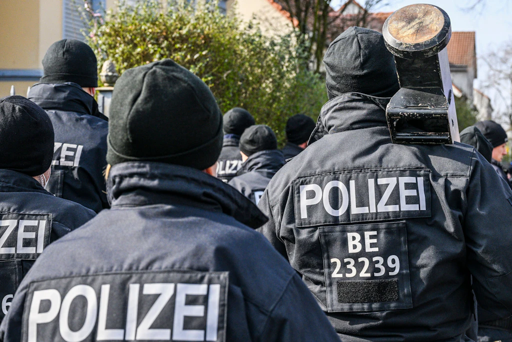 Polizisten, die eine Ramme bei sich tragen, bei einem Einsatz vor einer Villa aus dem Clan-Milieu