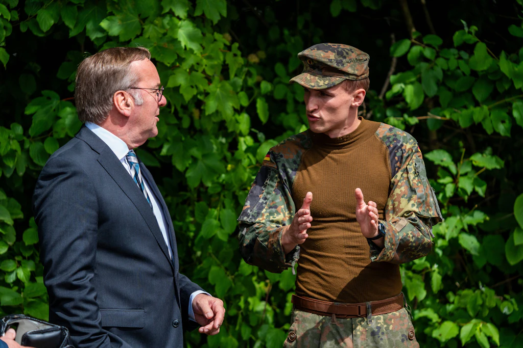Verteidigungsminister Boris Pistorius (SPD) spricht beim Tag der Bundeswehr in Neubiberg mit einem Soldaten.