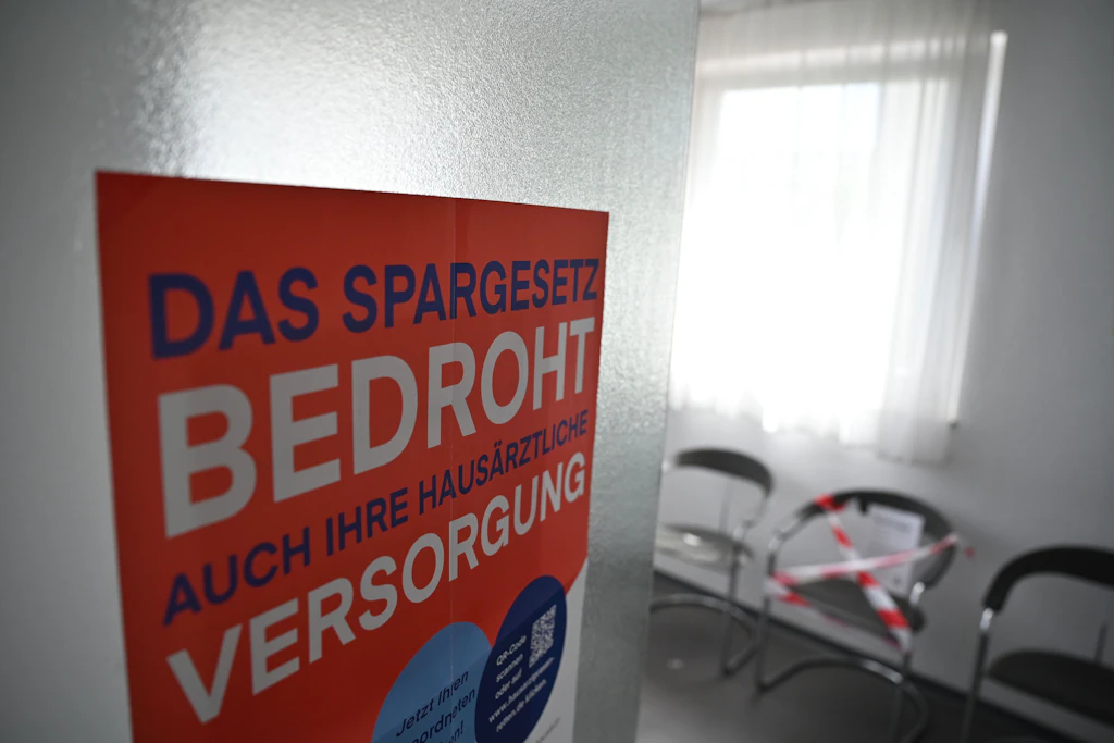 Am Eingang eines Wartezimmers hängt ein Protestplakat gegen das GKV-Spargesetz.