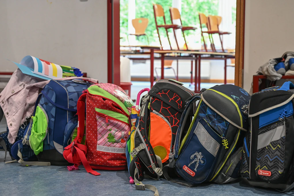 Schulranzen stehen vor einem Klassenzimmer.