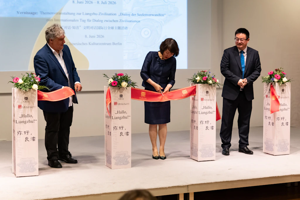 Shi Ling, Gattin des chinesischen Botschafters, durchschneidet das rote Band, begleitet von Abteilungsleiter des Ethnologischen Museums Maurice Mengel und Vizedirektor He Wenbo.