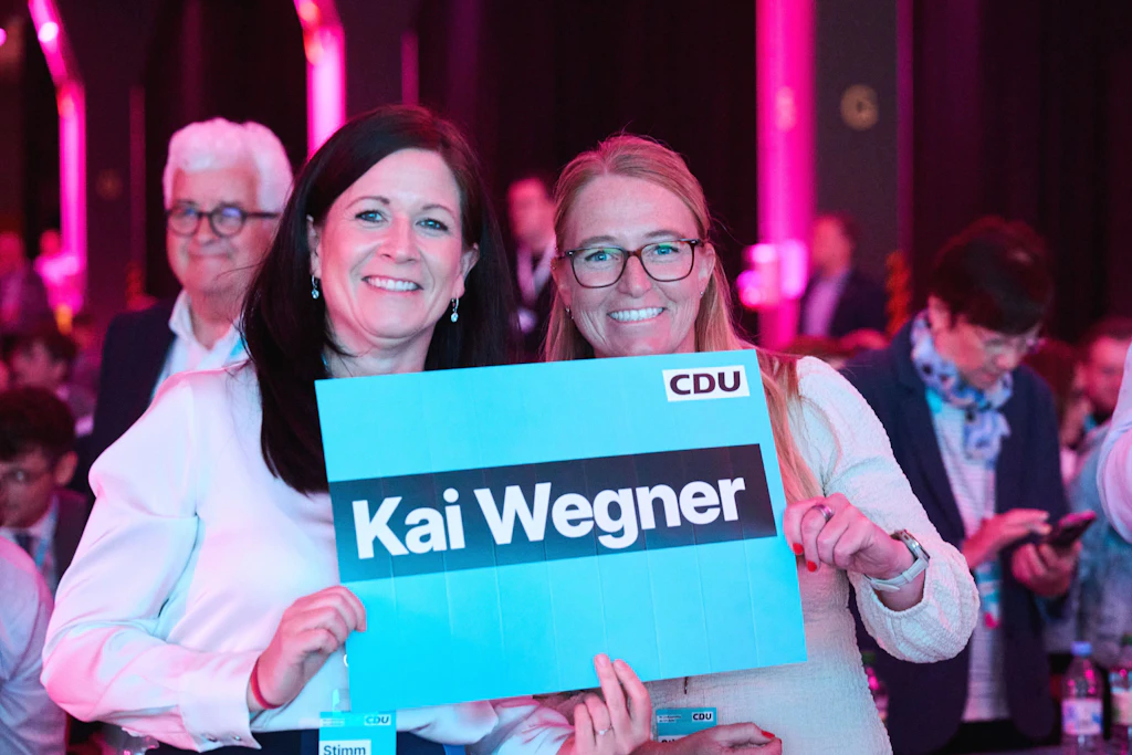 Katharina Günther-Wünsch (l.), Senatorin für Bildung, Jugend und Familie und Lebensgefährtin von Kai Wegner, hält zusammen mit Martina Patzwall ein Schild.