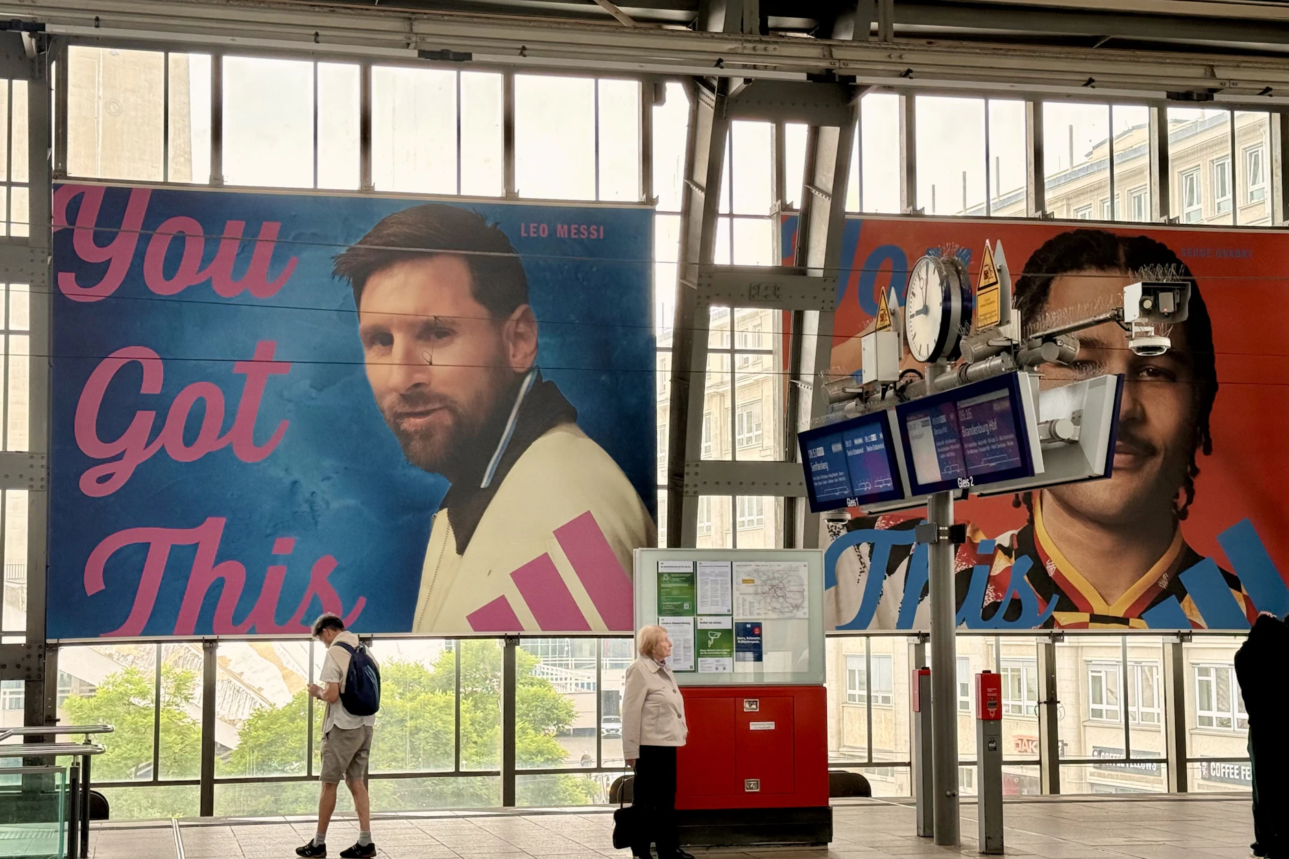 Am S-Bahnhof Alexanderplatz hängen riesige Werbeplakate von Adidas. Hier wird ausgerechnet für Profi-Kicker Messi (l.) geworben und sogar mit dem verletzten Serge Gnabry (r.).