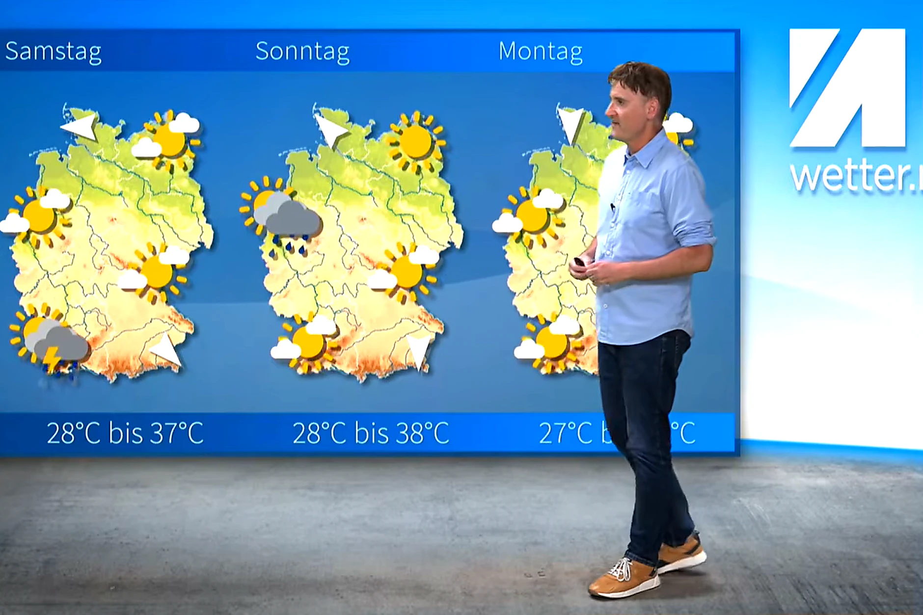 Meteorologe Dominik Jung steht vor der Wetterwand fürs kommende Wochenende, die Temperaturen von bis zu 38 Grad anzeigt.