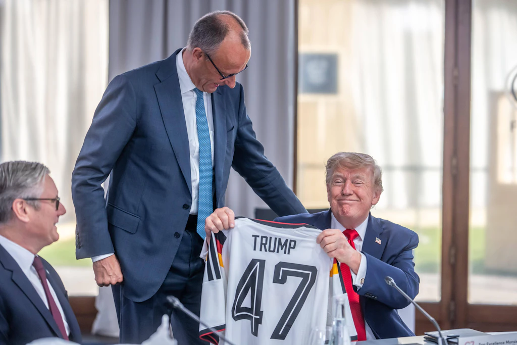 Bundeskanzler Friedrich Merz überreicht US-Präsident Donald Trump beim G7-Gipfel in Évian-les-Bains ein deutsches Fußballtrikot.
