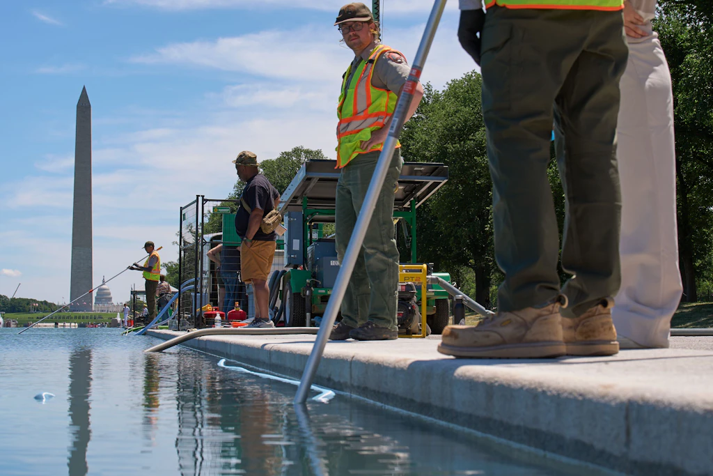 Mitarbeiter des National Park Service reinigen den Reflecting Pool am Lincoln Memorial von Algen.
