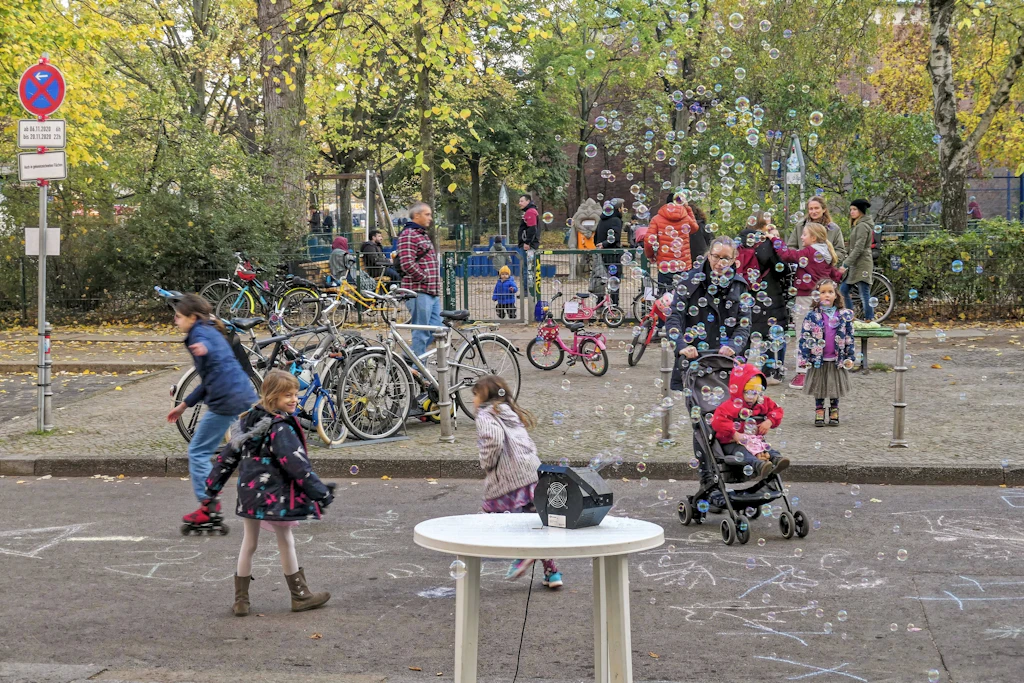 Eine Seifenblasenmaschine auf einem Campingtisch, Kinder auf Rollschuhen, kein Auto weit und breit: Alltag auf dem Lausitzer Platz in Kreuzberg.
