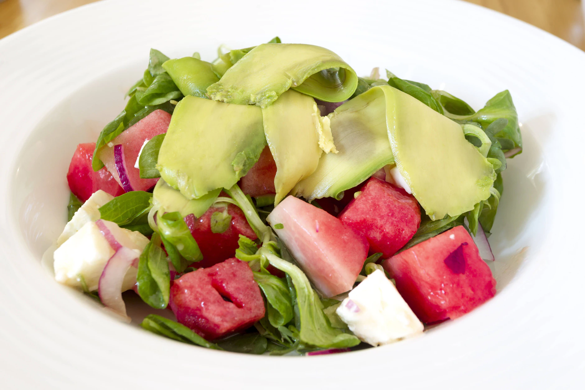 Nicht nur erfrischend, sondern dank der Avocado auch sättigend: Ein Sommersalat aus Melone, Avocado, Feldsalat und Feta.