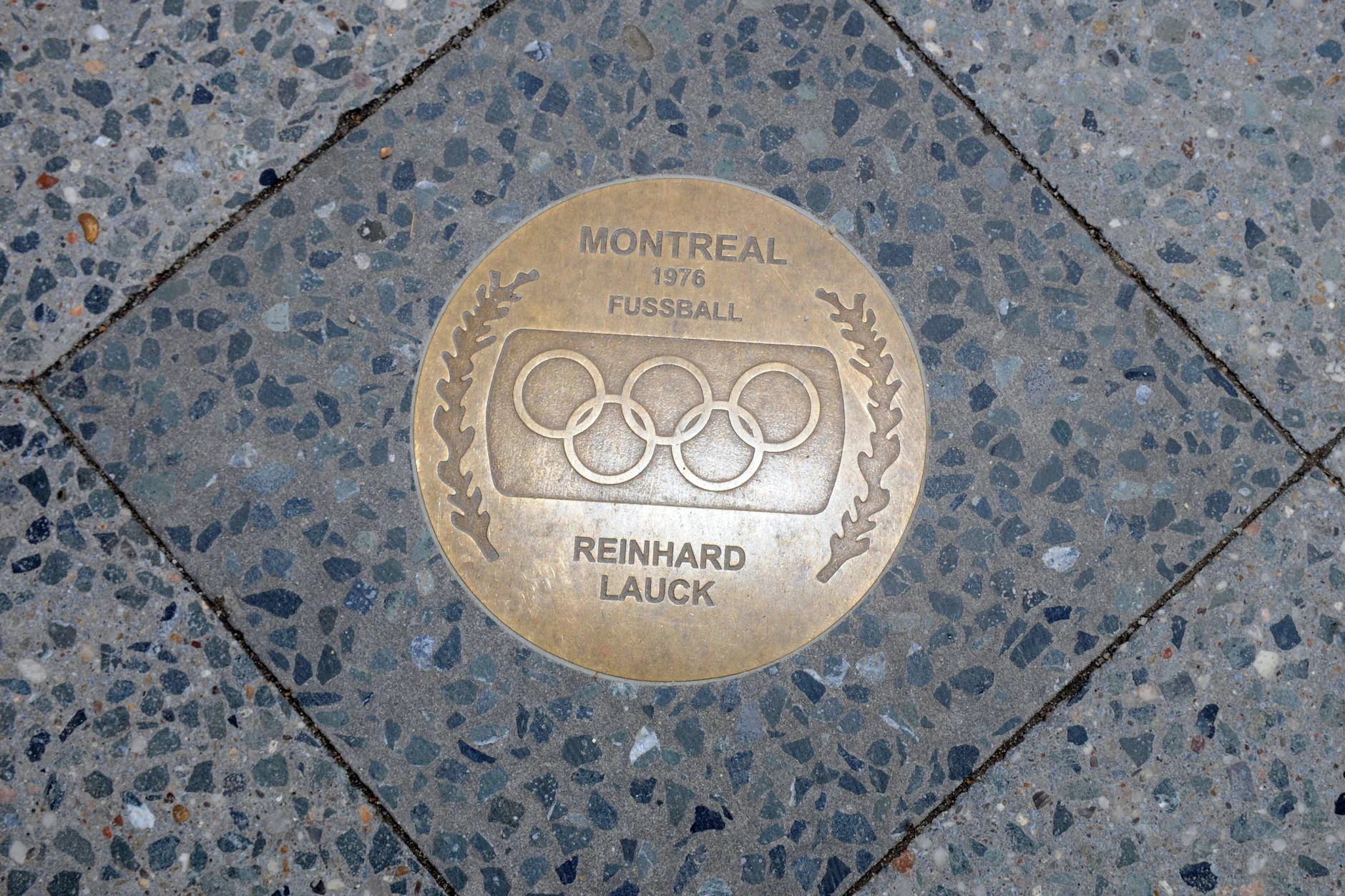 Die Gedenktafel für Reinhard Lauck auf dem Weg des Ruhmes der olympischen Medaillengewinner der Stadt Cottbus. 1976 gewann er mit dem Nationalteam der DDR in Kanada Gold.