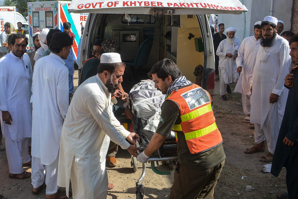 Freiwillige bringen in Bannu den Leichnam eines Opfers der beiden Sprengstoffanschläge zu einem Krankenwagen.