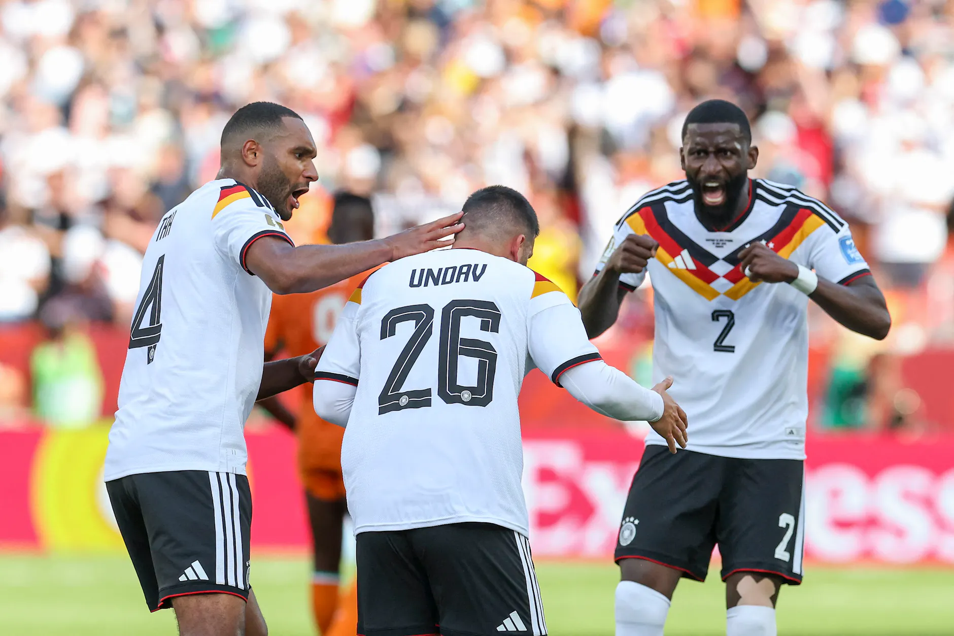 Jonathan Tah (l.) und Antonio Rüdiger (r.) freuen sich nach dem 1:1 mit Torschütze Dennis Undav.