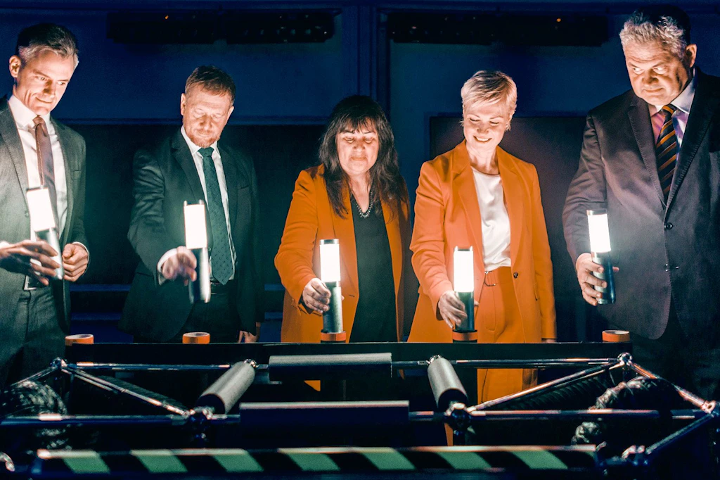 Manuela Schwesig, Michael Kretschmer und weitere Vertreter aus Wissenschaft und Politik halten bei der symbolischen Gründung der High Energy Density Initiative (HEDI) Leuchtstäbe.