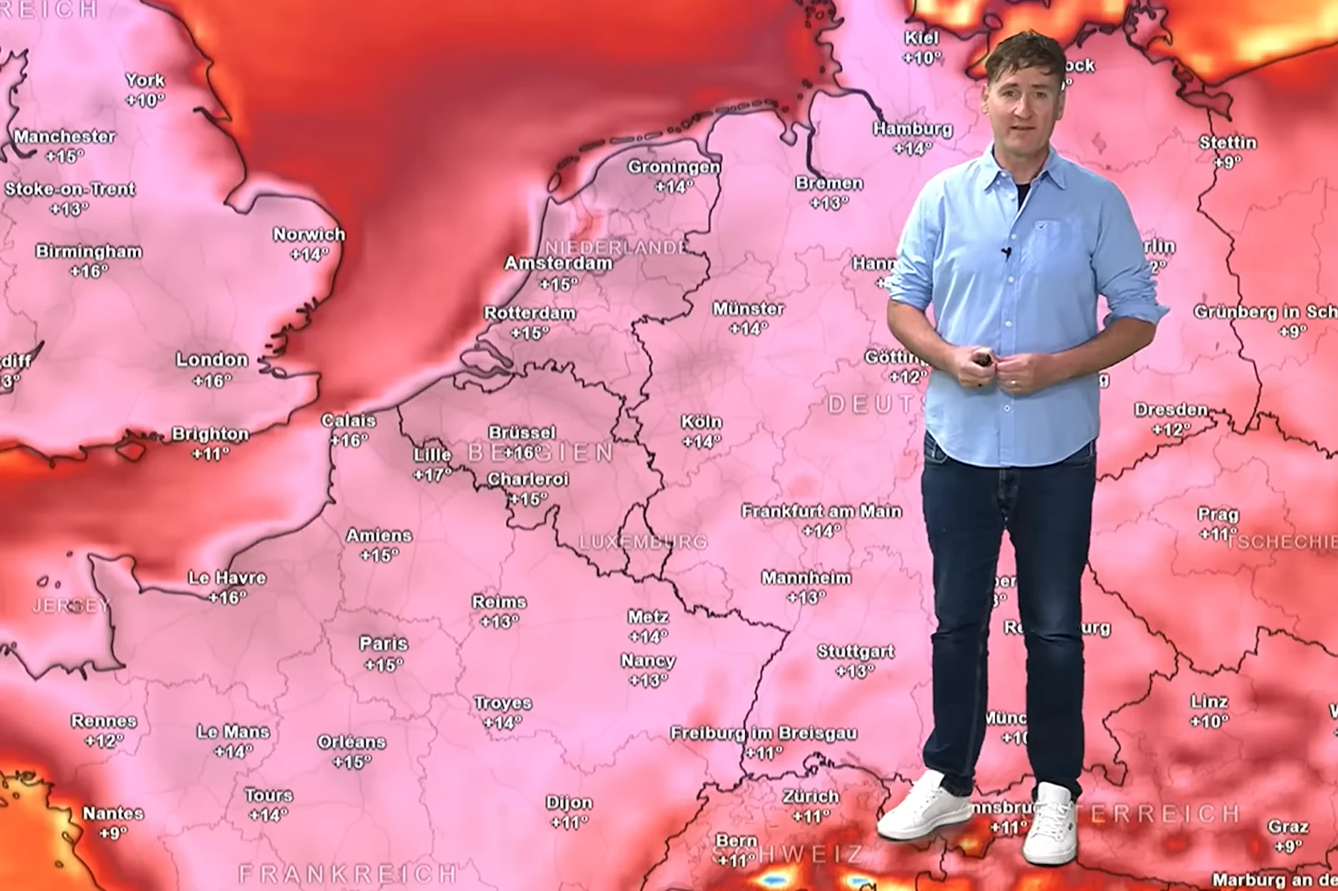 Meteorologe Dominik Jung von wetter.net steht vor einer Wetterkarte, die anzeigt, um wie viel Grad wärmer als normal es zur Zeit in verschiedenen Regionen von Europa es ist.