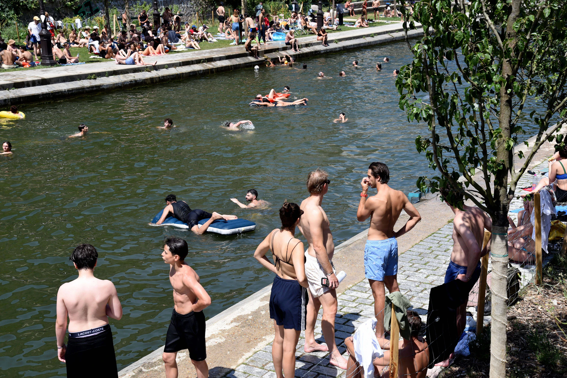 Abkühlung in der Großstadt: In Paris suchen Menschen bei extremer Hitze Erfrischung im Wasser eines Kanals. In Frankreich sind bereits 40 Menschen beim Baden ertrunken.