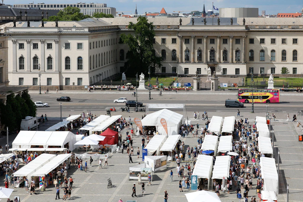 Blick auf das Berliner Bücherfest 2025 – diesmal gibt es noch mehr Sonnenschirme.