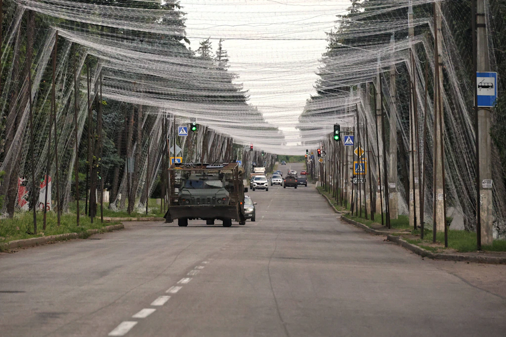 Ein ukrainisches Militärfahrzeug fährt auf einer mit Anti-Drohnen-Netzen geschützten Straße in der Region Donezk.
