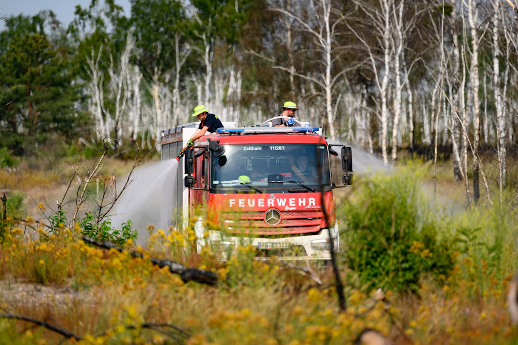 Feuerwehrleute sind bei einem Waldbrand in der Gohrischheide im Einsatz.