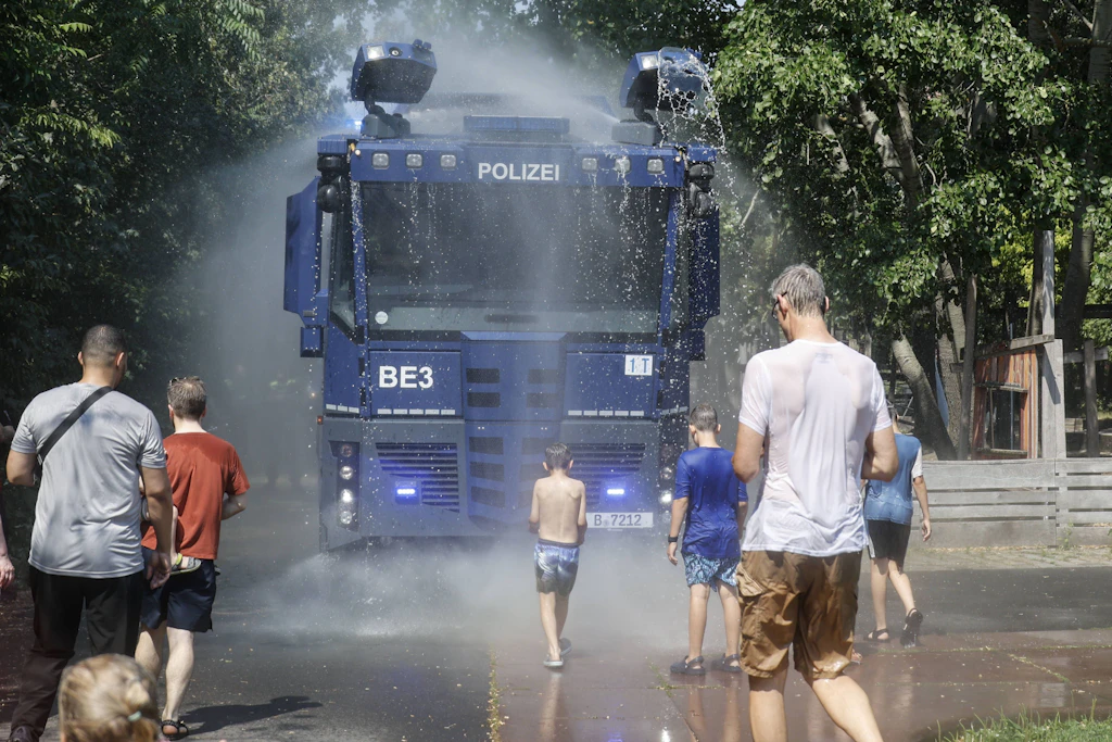Mit Wasserwerfern verschafft die Berliner Polizei Besuchern im Park am Gleisdreieck eine Abkühlung während der Rekordhitze.