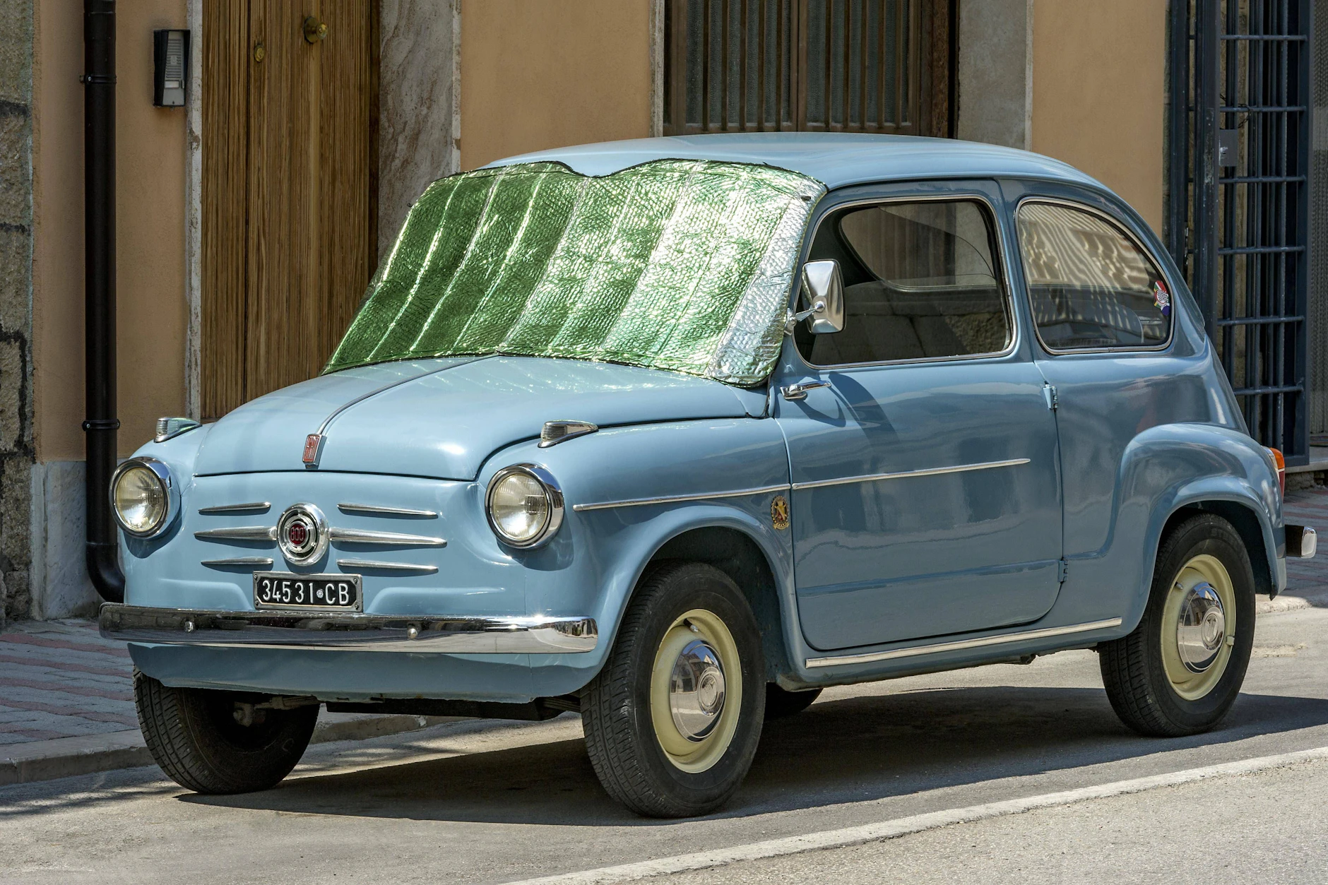 Auch bei Oldtimern wie diesem Fiat Seicento: Reflektierende Folie, die außen auf die Windschutzscheibe gelegt wird, ist der zweitbeste Sonnenschutz am Auto.