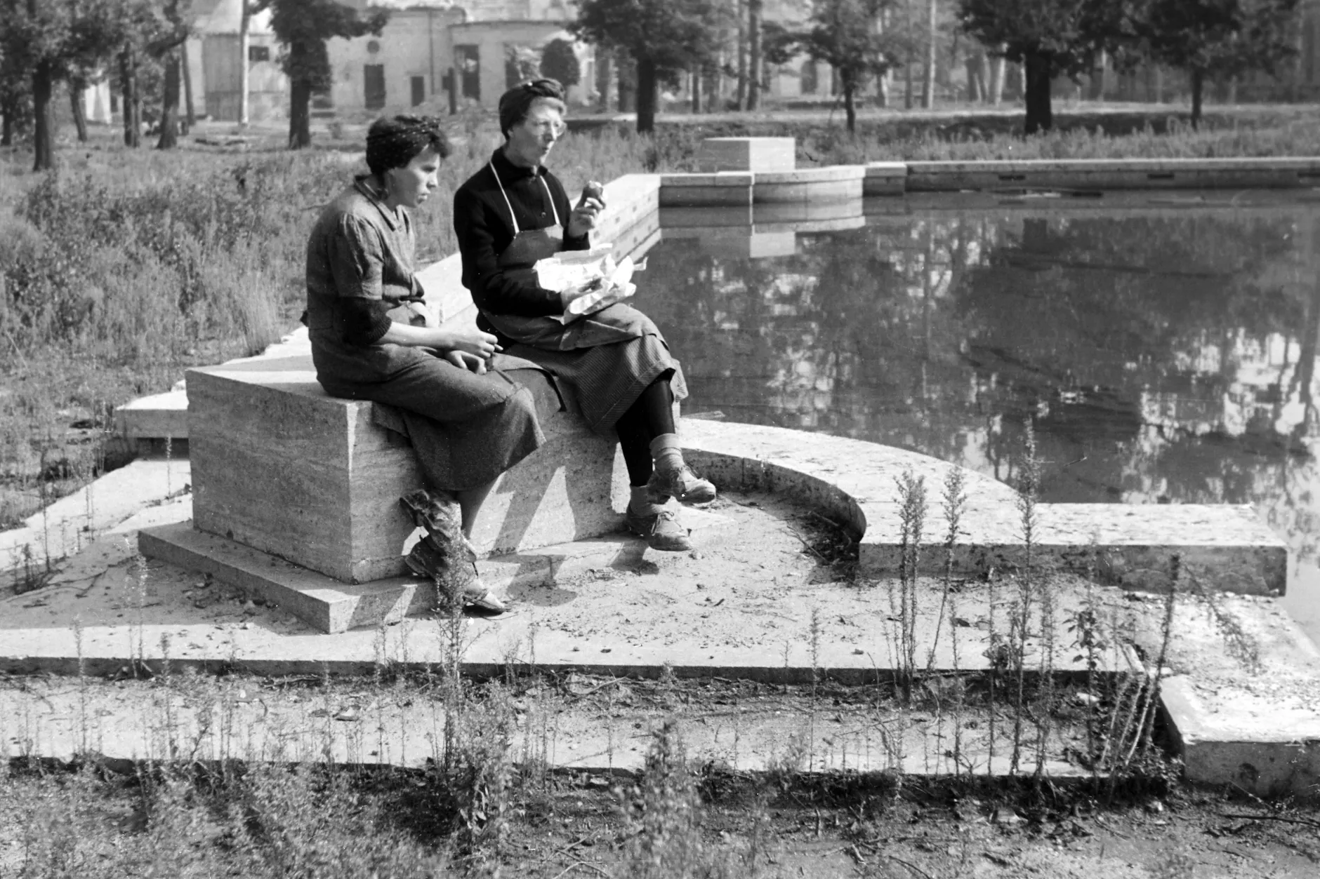 Zwei Frauen verbringen ihre Mittagspause am Teich der Neuen Reichskanzlei, 1946.