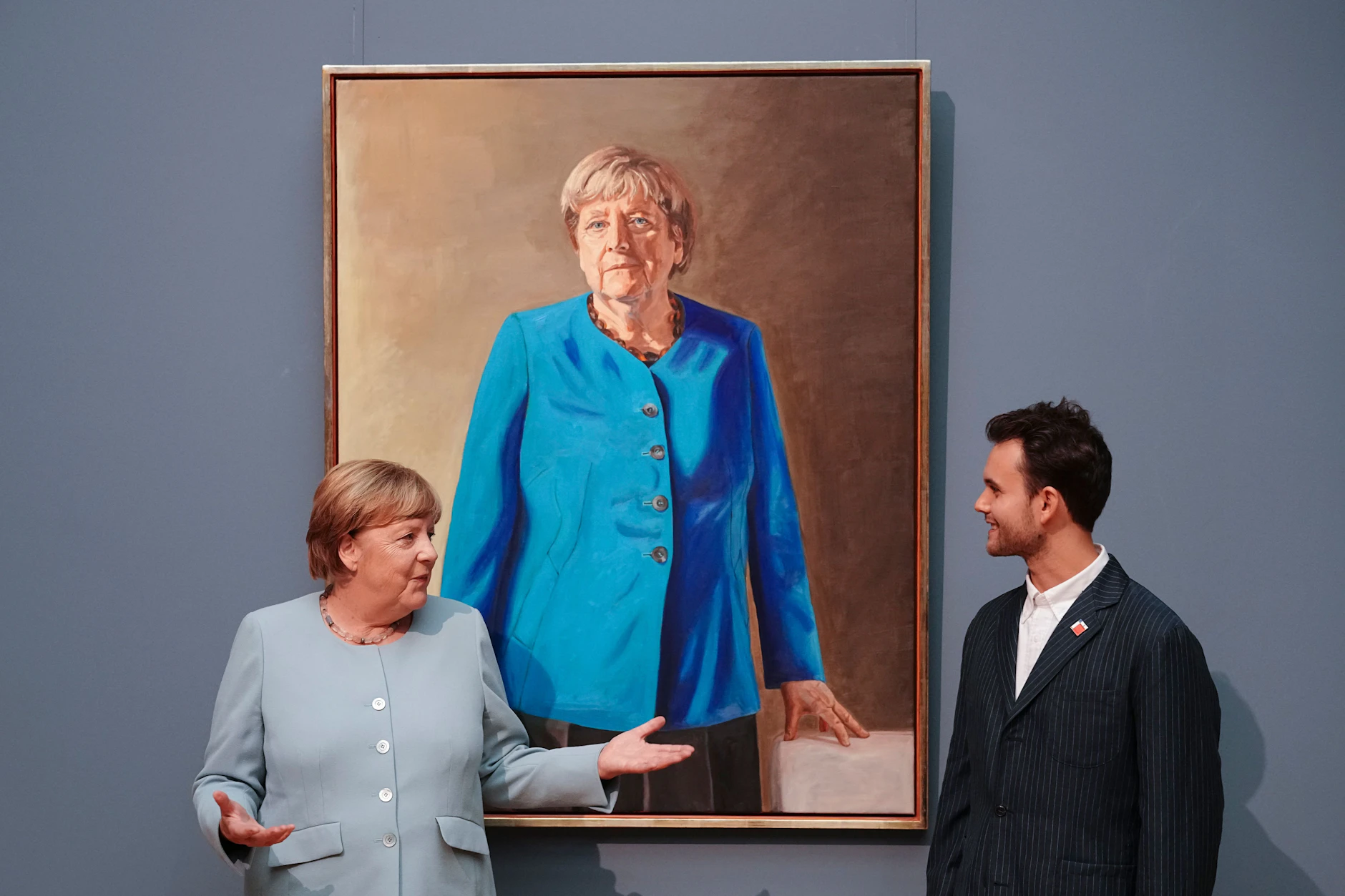 Die frühere Bundeskanzlerin Angela Merkel und der Künstler Jérémie Queyras vor dem Porträt, das er von ihr gemalt hat.
