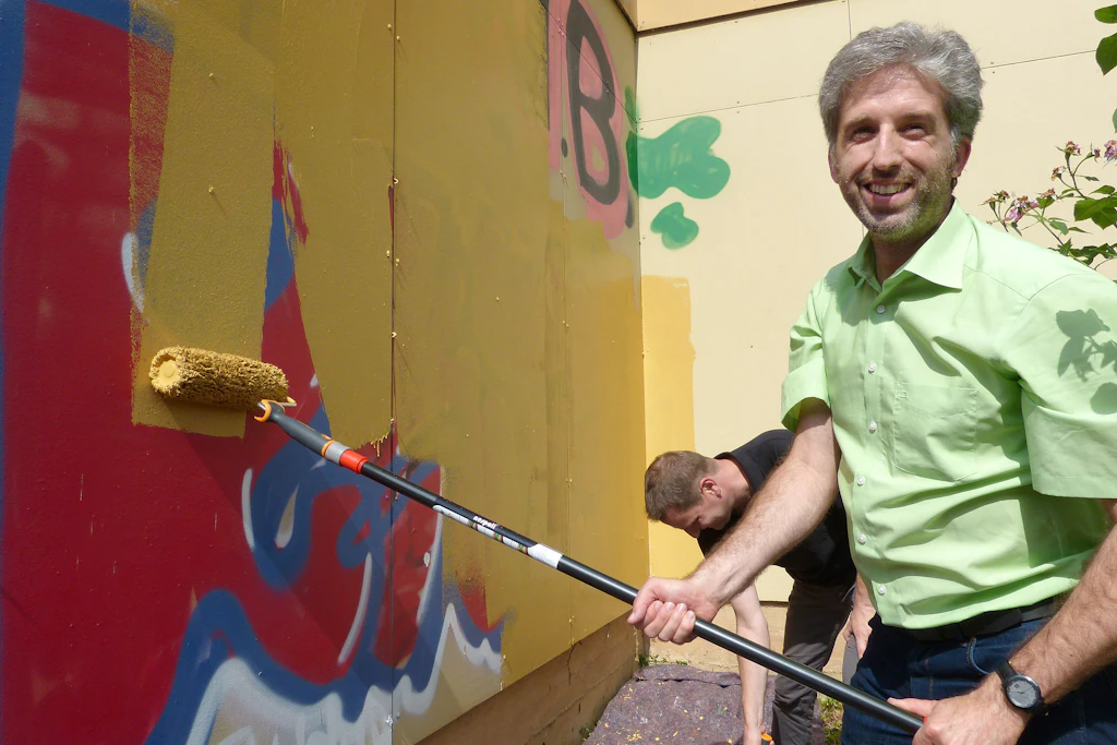 Boris Palmer (inzwischen parteilos), Oberbürgermeister von Tübingen, überstreicht Graffiti an einem Musikschulgebäude seiner Stadt (Archivfoto).