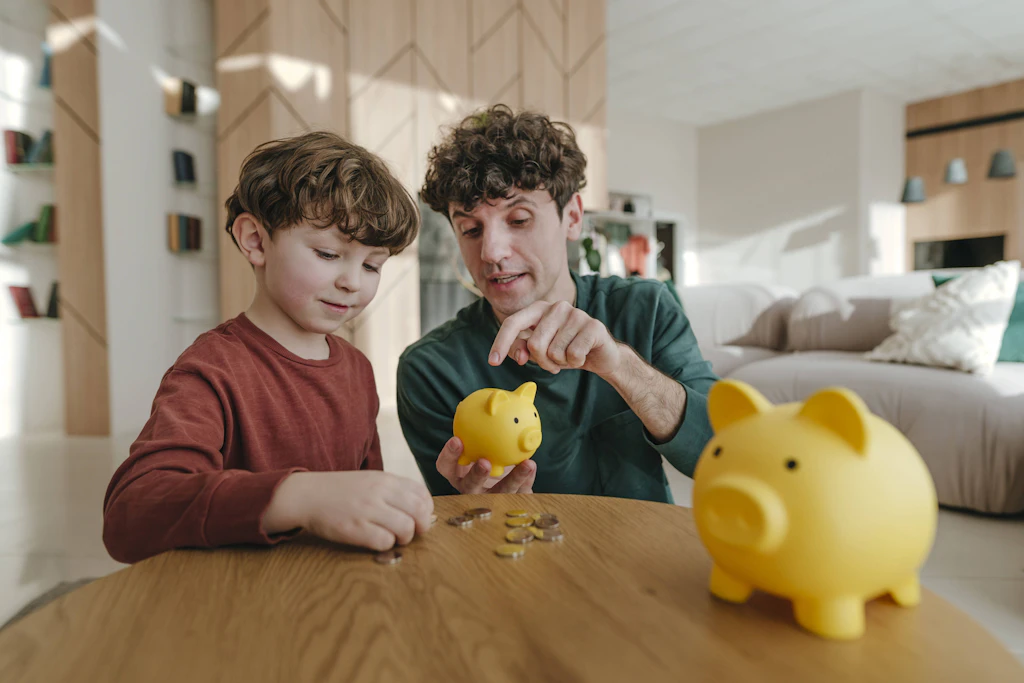 Ein Vater und sein Sohn stecken Münzen ins Sparschwein. Mit der geplanten Frühstartrente zahlt der Staat Kindern ab dem Jahrgang 2020 zehn Euro im Monat in ein Aktiendepot. (Symbolbild)