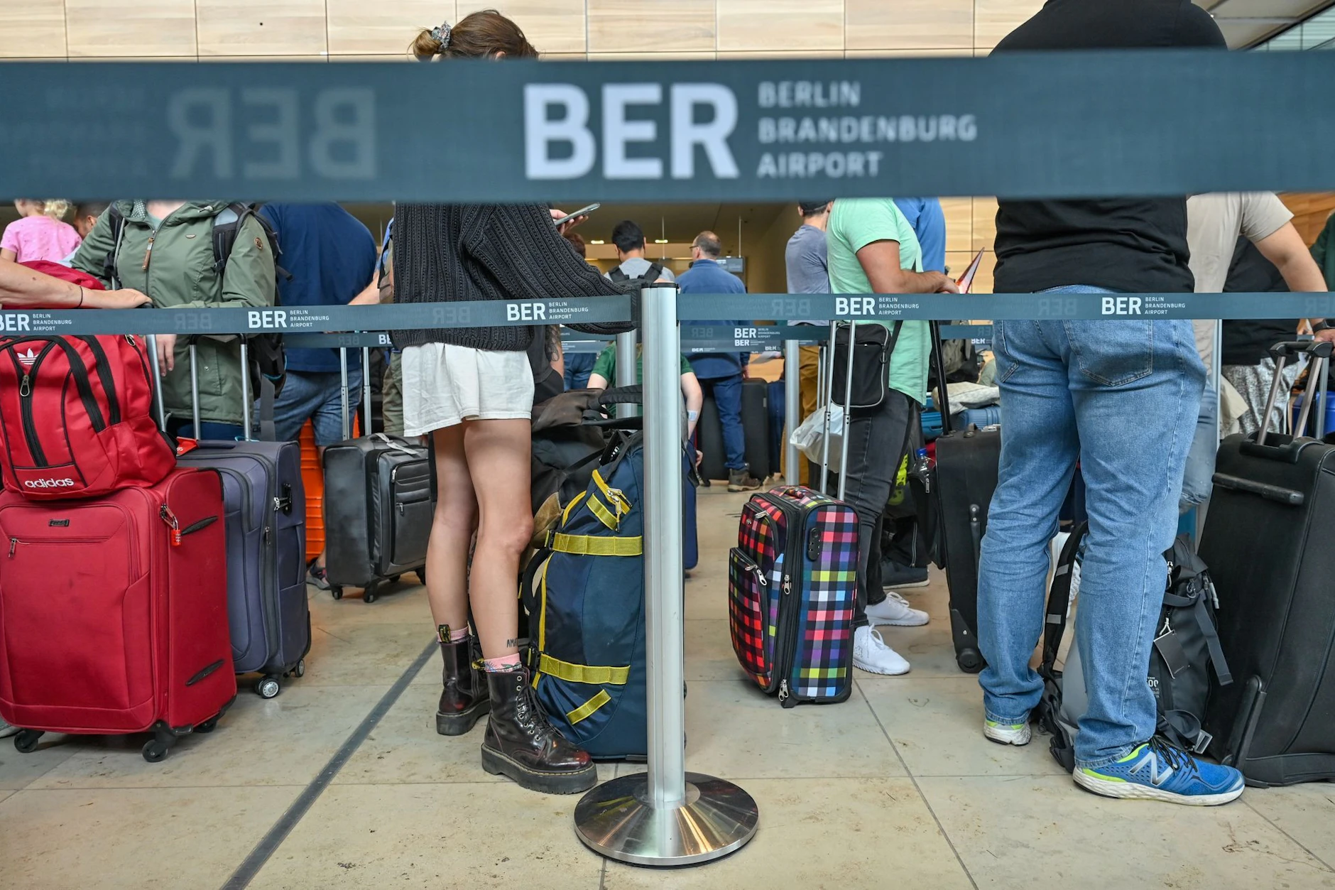 Reisende warten an einem Check-in für ihren Abflug vom Hauptstadtflughafen Berlin Brandenburg.