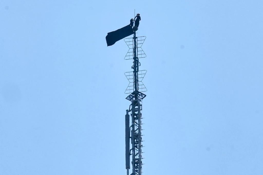 Eine Person steht auf der Spitze der Antenne des Empire State Building.