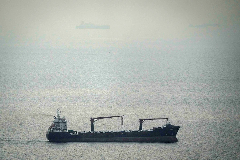 Ein mit Fahrzeugen beladenes Frachtschiff fährt durch den Arabischen Golf in Richtung der Straße von Hormus.