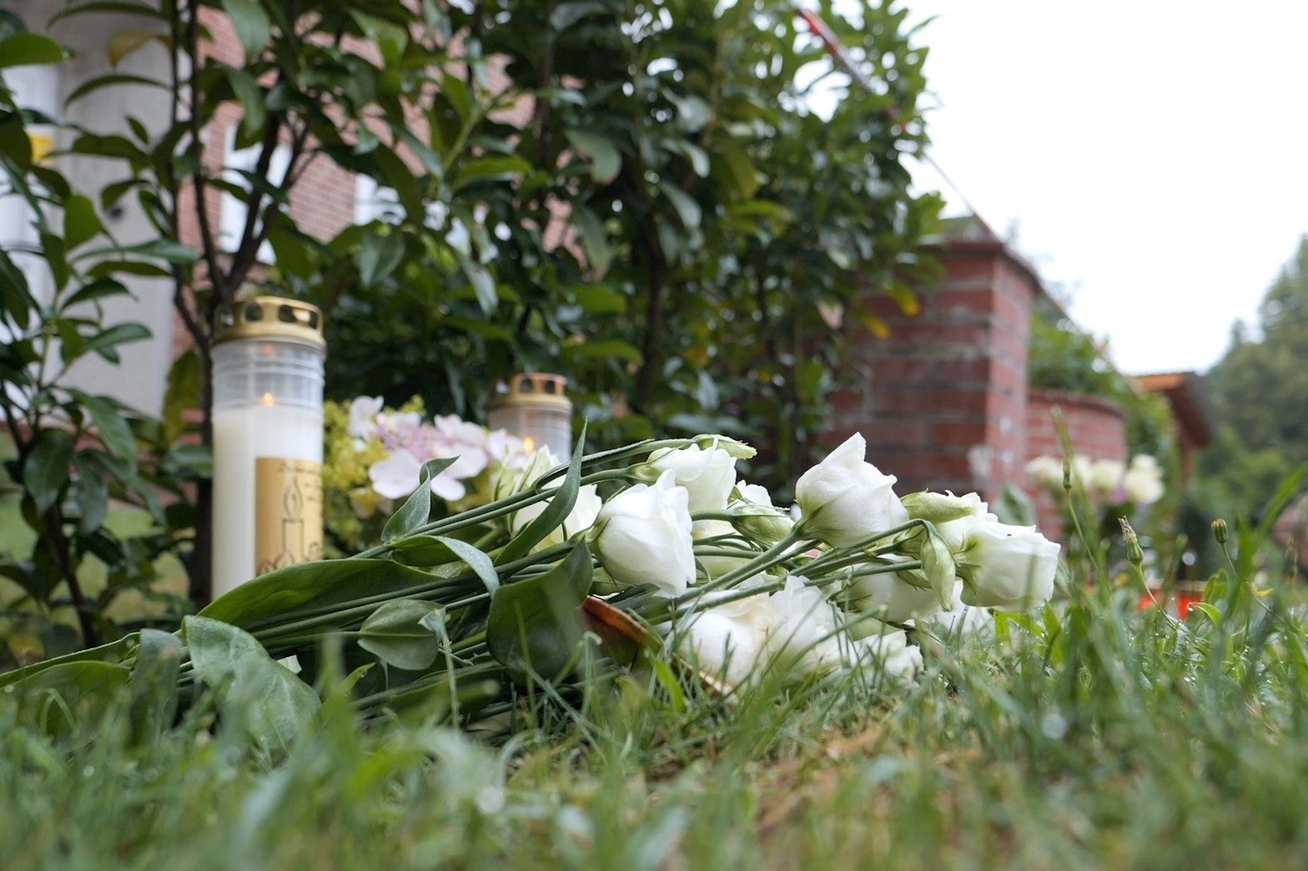 Blumen und Kerzen liegen und stehen vor dem Gebäude der Mutter-Kind-Einrichtung in Stade. Vier Frauen und zwei Männer wurden hier erschossen.